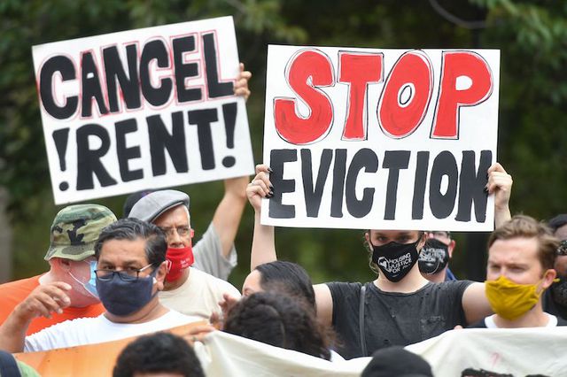 Demonstrators wearing masks and holding posters saying "Cancel Rent" and "Stop Eviction" at a rally calling for an extension of the state's eviction ban until 2022 and the cancellation of rent at Cadman Plaza Park in Brooklyn.
